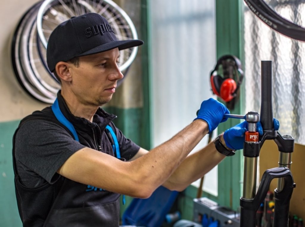 Florian en train d’entretenir une fourche de Vélo Tout Terrain (VTT)