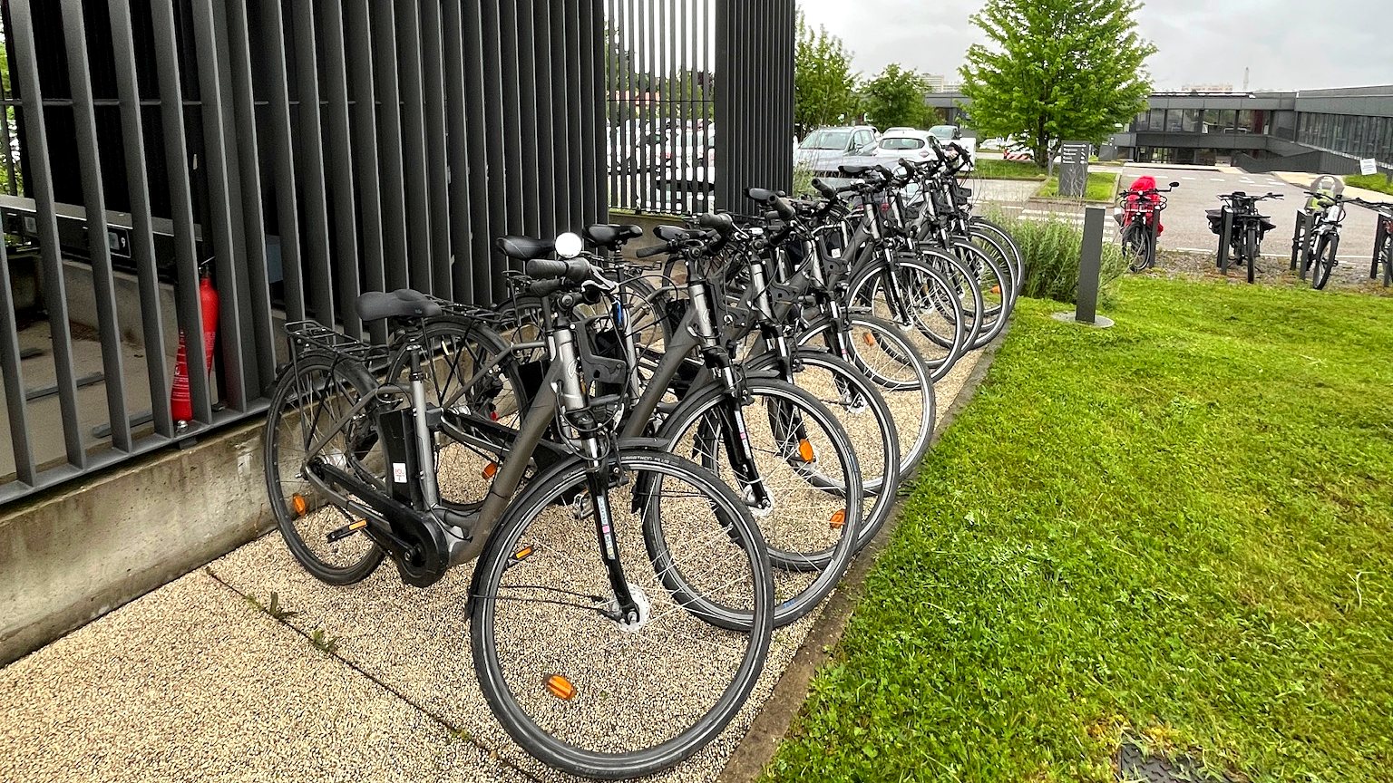 Rangée de vélos à assistance électrique stationnés devant un bâtiment d’entreprise